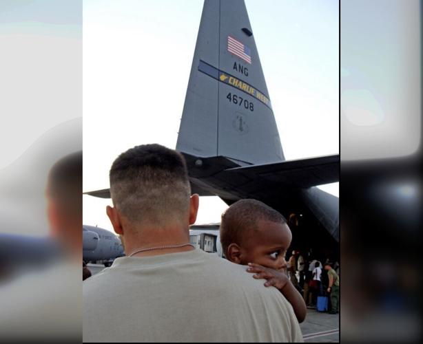 Cody De Los Reyes holding Haitian child