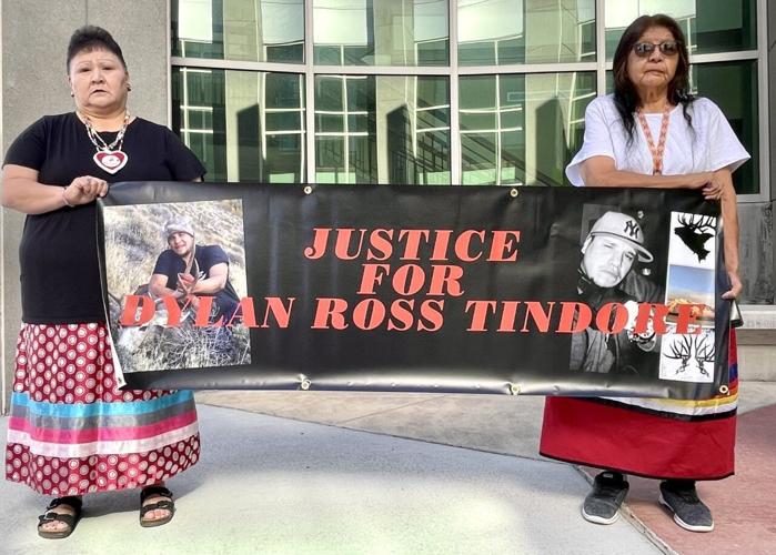 Tindore damily holds sign demanding justice