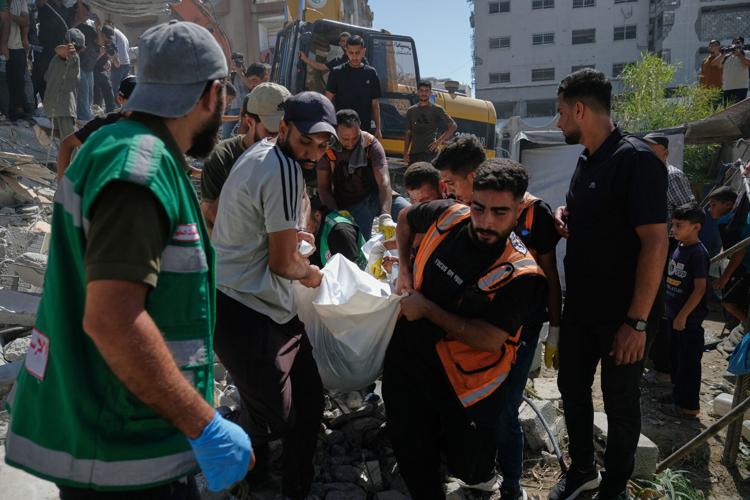 Photos show rescuers recovering bodies after strike-damaged building collapses in Gaza