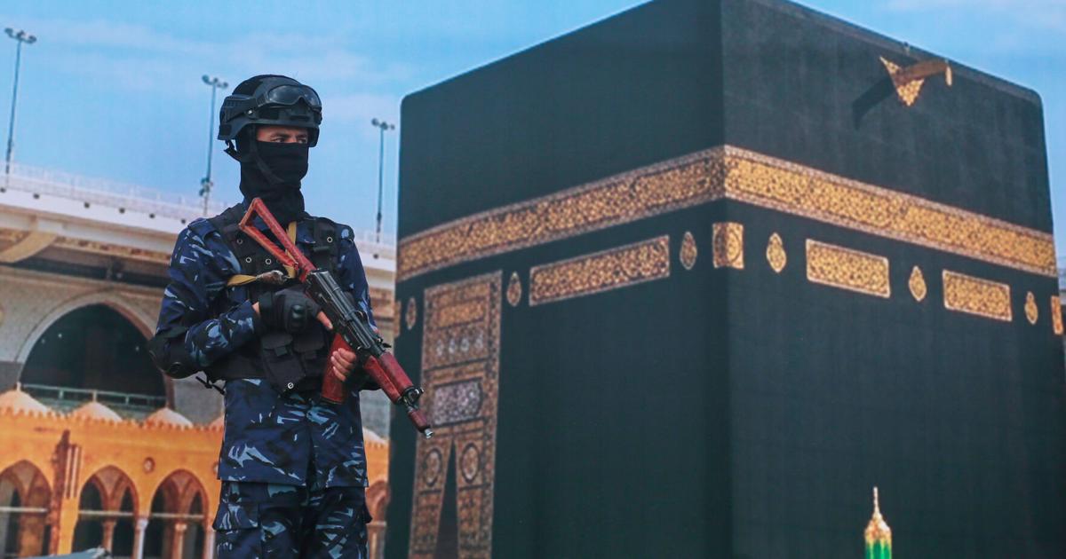 Houthi rebels rally in Sanaa to protest Saudi Arabia's accusation that they targeted the Kaaba; soldier stands before giant Kaaba banner