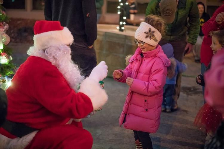 Santa presents a present to a child