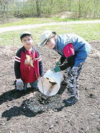 father and son digging ground in forest with shovels, ecology