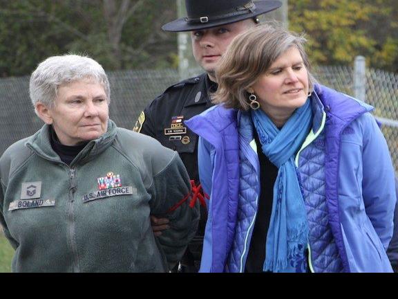 Colleen Boland, left, and Sandra Steingraber, right, being arrested for