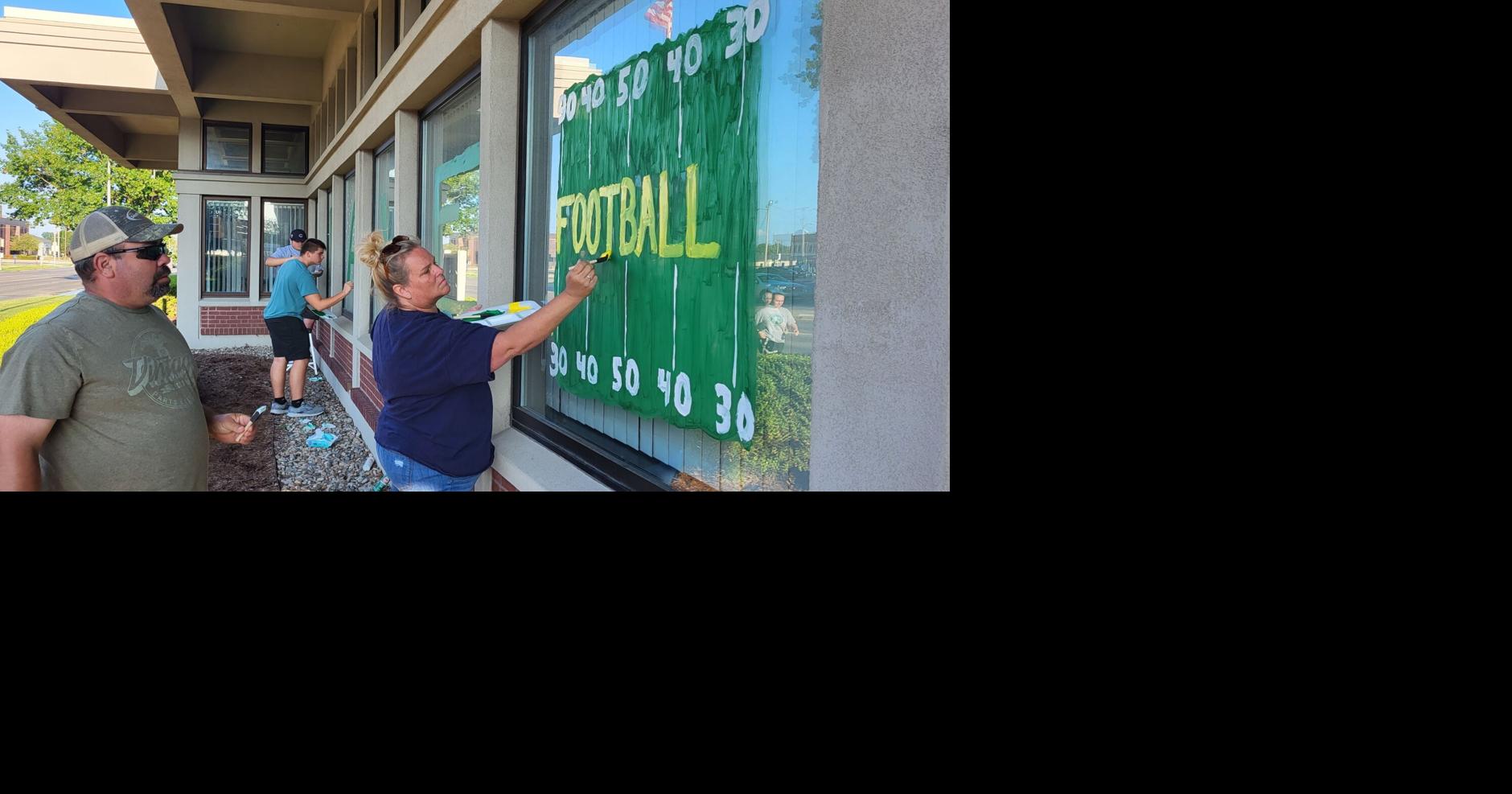 MHS Huddle painting windows for first Mattoon home football game of the season
