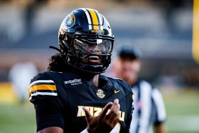 Missouri quarterback Austin Simmons smiles and points while dressed in uniform (copy)