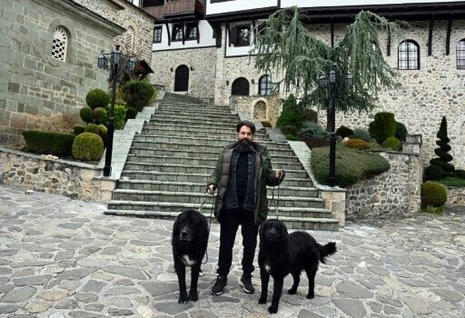 Ilija Karov, president of a kennel club devoted to the Karaman breed, walks two of the dogs at the Bigorski Monastery in North Macedonia