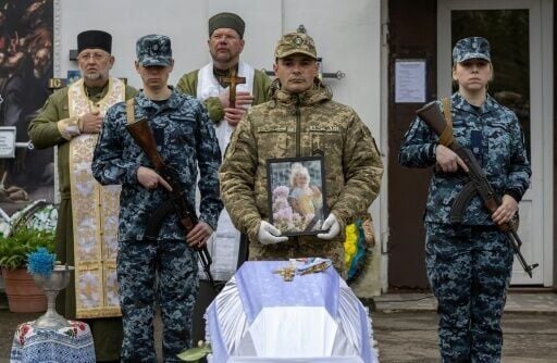 Ukraine soldiers at the funeral of a child killed in a Russian drone attack on a multi-storey residential building in Odesa