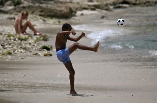 A boy kicks a ball at Sint Michiel beach in Curacao, the Caribbean island that became the smallest country ever, by population, to qualify for football's World Cup