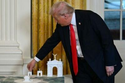 US President Donald Trump, seen on October 15, 2025 displaying early models for a proposed huge arch for Washington, says the structure will be the 'most beautiful triumphal arch anwhere in the world'