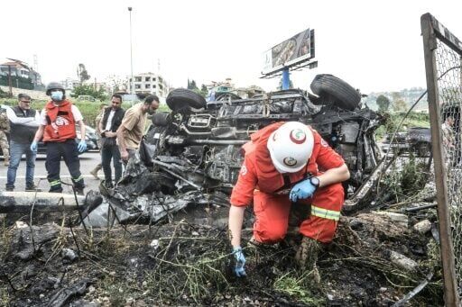 First responders inspect the site of an Israeli strike on a vehicle in the Lebanese town of Jiyeh, south of Beirut