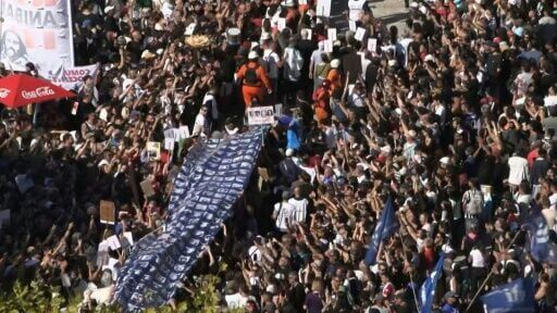 Demonstrators carry a large banner with portraits of disappeared people during a march to Plaza de Mayo
