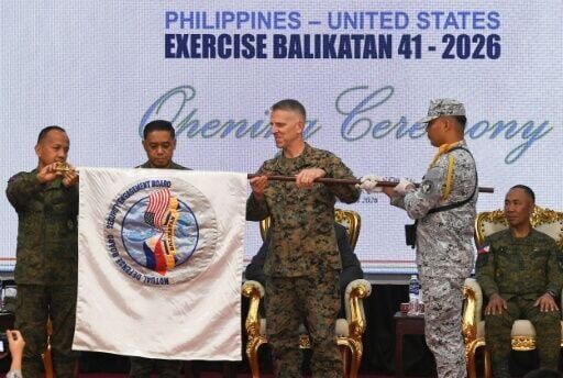 (L-R) Philippine Major General Francisco Lorenzo, Philippine military Chief General Romeo Brawner, and US Lieutenant General Christian Wortman, commanding general of the Marine Expeditionary Force, unfurl the Balikatan exercise flag