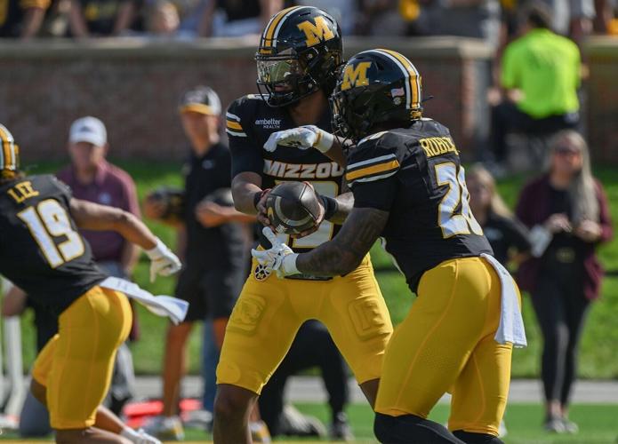 Mizzou quarterback Austin Simmons (13) hands off the ball to Mizzou running back Jamal Roberts (20)