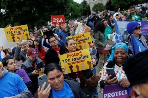 Demonstrators chant and hold signs outside the US Supreme Court as it weighs ending temporary protected status for Haitians and Syrians