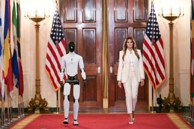 US First Lady Melania Trump walks with a humanoid robot as she arrives for the Fostering the Future Together Global Coalition Summit in the White House
