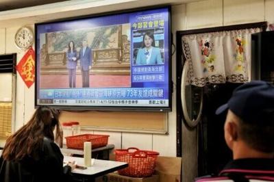 A television shows the meeting between Kuomintang chairwoman Cheng Li-wun and Chinese President Xi Jinping in Beijing, at a restaurant in Taipei on April 10