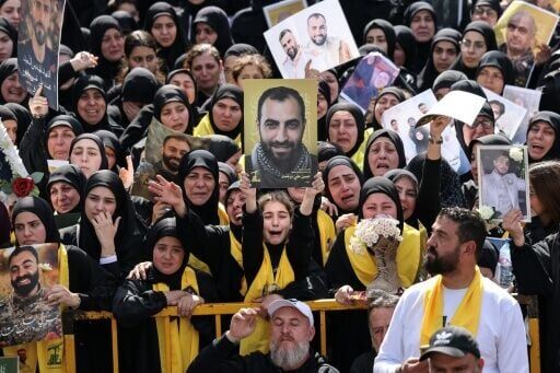 Mourners hold up portraits of Hezbollah fighters killed by Israel in the recent war
