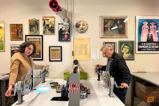 Nitrate Film Vault technician Courtney Holschuh (L) and vault leader George Willeman (R) unspool film on reels at the Library of Congress Audio-Visual Conservation Center