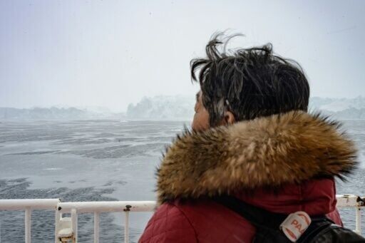 A passenger looks at the icebergs of the Icefjord near Ilulissat, Greenland