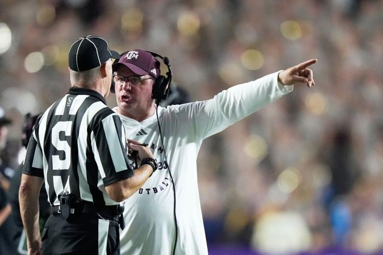 Texas A&M coach Mike Elko challenges an official