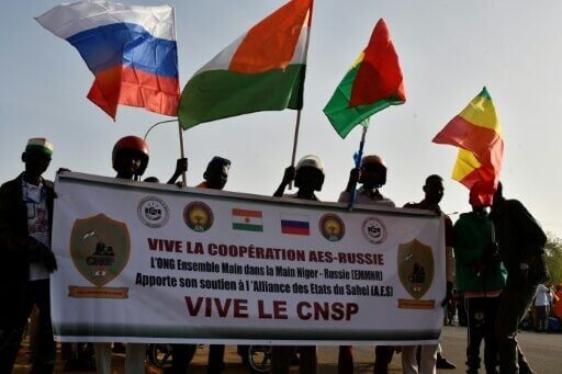 People in Niamey wave flags from Russia, Niger, Burkina Faso and Mali during a gathering to celebrate the withdrawal of the three African states from the Economic Community of West African States (ECOWAS) in January 2025