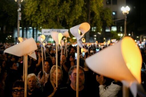 Marchers held illuminated white scarves aloft at a vigil for the regime's victims