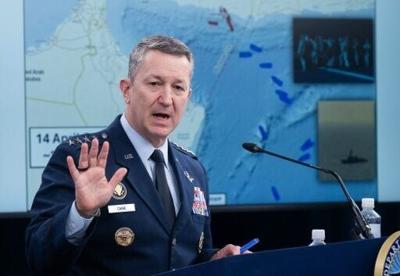 US Chairman of the Joint Chiefs of Staff General Dan Caine speaks as a map of the Strait of Hormuz is displayed during a press briefing
