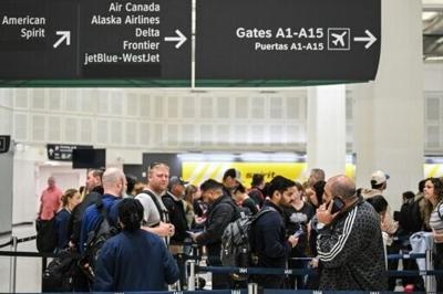 Travelers wait in line at a TSA security checkpoint at George Bush Intercontinental Airport in Houston, Texas on March 20, 2026
