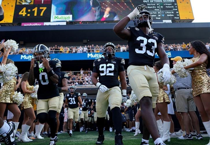 From left, Mizzou wide receiver Naeshaun Montgomery (0), Mizzou nose tackle Jason Dowell (92), and Mizzou linebacker JJ Bush (33) run onto the field