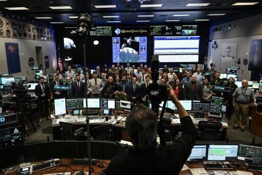 NASA staff pose for a group photo in the White Flight Control Room at Johnson Space Center in Houston, Texas, on April 6, 2026