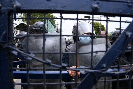 Police stand guard while Nepali former prime minister KP Sharma Oli's supporters protest against his arrest in Kathmandu on March 29, 2026.