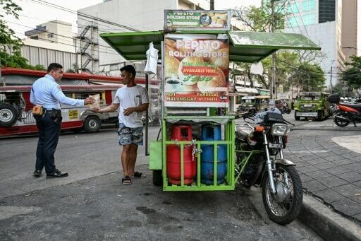 A man sells the popular breakfast roll 'pandesal' in Manila