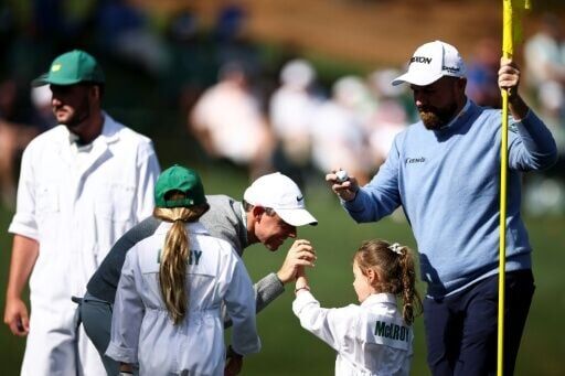 Defending champion Rory McIlroy, the world number two from Northern Ireland, celebrates with his daughter Poppy on the ninth green at the Masters Par-Three Contest