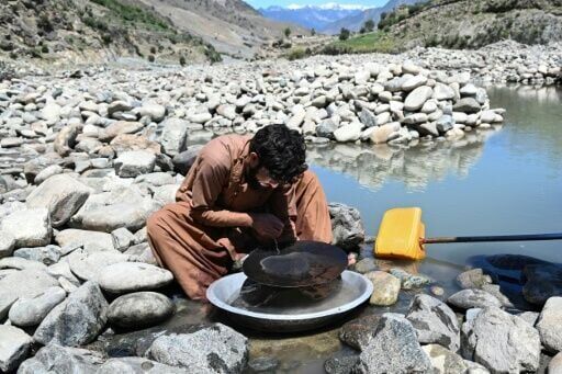 An Afghan man scours for gold using the traditional gold-panning technique allowed by authorities