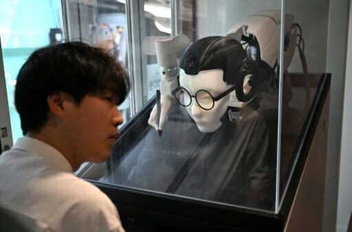 Across the room, a bespectacled robot uses a camera and a mechanised arm to sketch and "read" a visitor's face, foretelling their prospects