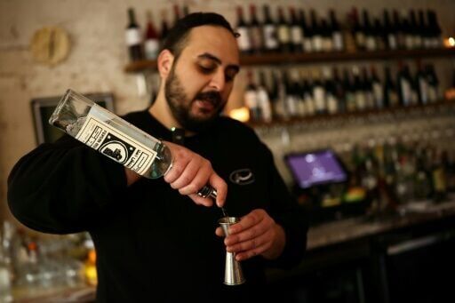 A bartender prepares a cocktail using a bottle of traditional Iranian spirit known as aragh sagi at a restaurant in Brooklyn