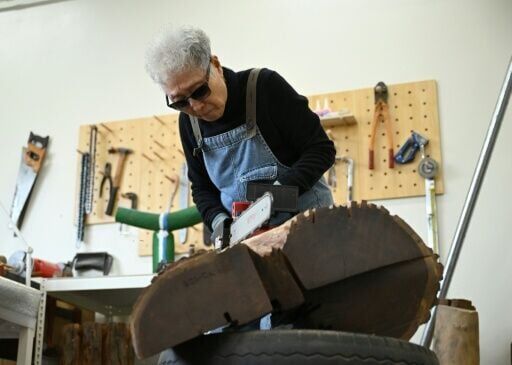 South Korean sculptor Kim Yun Shin wields a chainsaw with a quiet focus, refining a craft the 91-year-old has honed over decades spent far from home