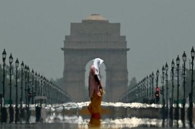 Summer heat in the world's most populous nation can be brutal -- here a woman walks past India Gate in New Delhi in June 2025
