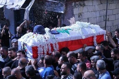 Mourners carry the coffin of Lebanese journalist Amal Khalil during her funeral procession in the southern town of Bissariye