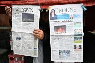 A vendor displays morning newspapers at his roadside stall in Islamabad after Pakistan's Prime Minister Shehbaz Sharif said Islmabad would host negotiations between the United States and Iran