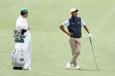 Thai amateur Fifa Laopakdee, right, talks with caddie Santiago Botero on the 11th hole during a practice round ahead of the 90th Masters