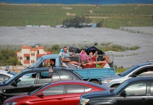 Displaced residents travel back to their homes via the bombed Qasmiyeh bridge over the Litani River