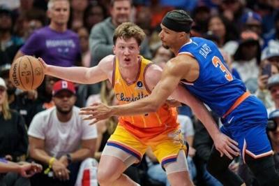 Josh Hart of the New York Knicks attempts to guard Charlotte's Kon Knueppel