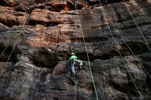 A young climber scales a rock wall in India