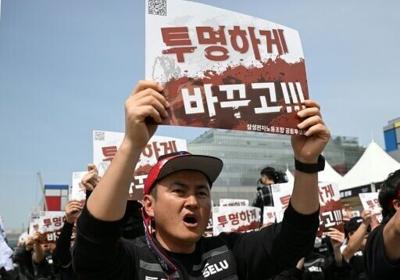 Members of the Samsung Electronics labour union hold signs reading "Change it to be transparent!" as they stage a mass rally demanding the removal of a cap on performance bonuses, outside the company's foundry and semiconductor factory in Pyeongtaek on ...