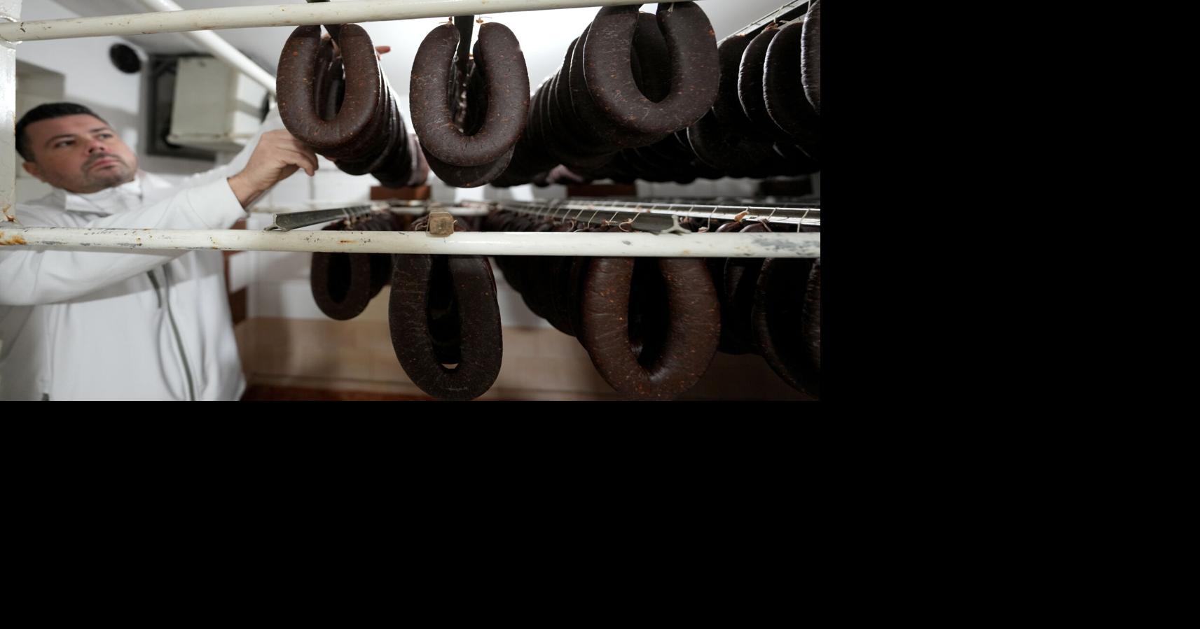 A traditional sausage in the shape of a horseshoe is 'ironed' for dryness in southeastern Serbia