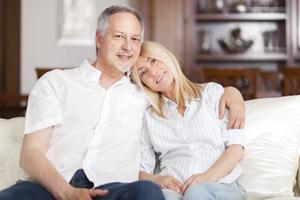 Senior Couple Relaxing On Sofa At Home