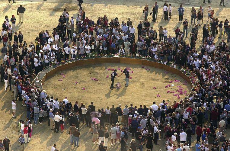 Two family members of 9/11 victims shake hands on Sept. 11, 2002 after laying flowers in the middle of a circle set up at Ground Zero on the first anniversary of the World Trade Center attacks.