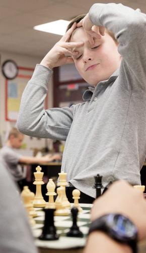 The little boy ponders the next chess move. Stock Photo