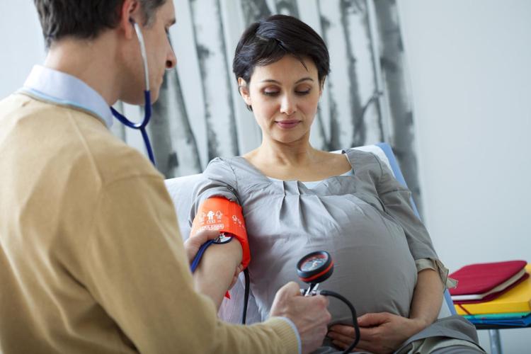 Pregnant Latina mom with doctor